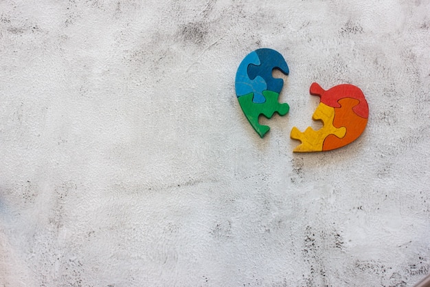 Wooden multicolor puzzle in the form of heart on gray