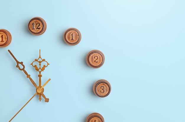 Wooden numbers and clock hands on blue background