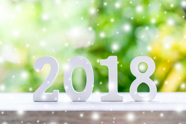 나무 테이블 배경에 눈이 새 해에 대 한 숫자 2018을 형성하는 나무 숫자.