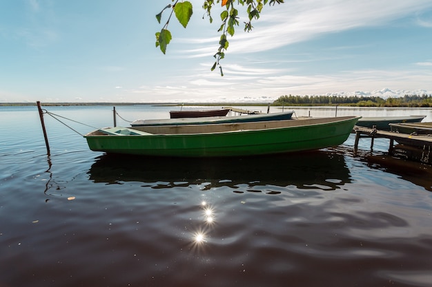 Wooden old fishing boats at the pier on the lake.