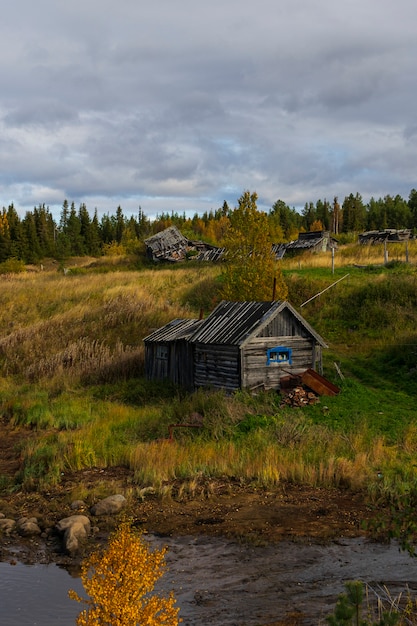 Wooden old house on the river, far outside the city, Murmansk region in autumn, landscape