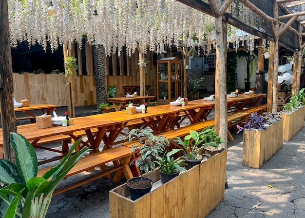 녹색 식물이 있는 파티오 테라스 정원의 목재 야외 테이블과 의자 벤치