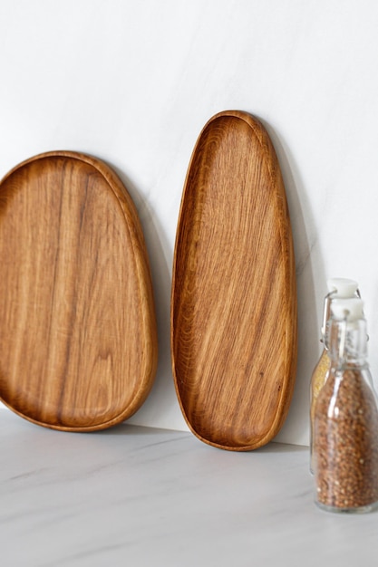 Wooden oval oak dishes boards trays standing near the wall Empty wooden plates on kitchen table