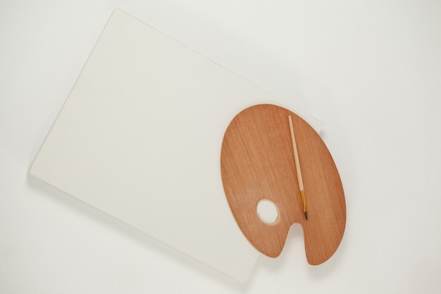 Wooden palette and paint brush on wooden table