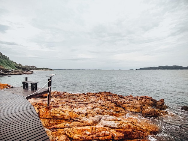 Wooden path along a beautiful rocky coast and stone beach