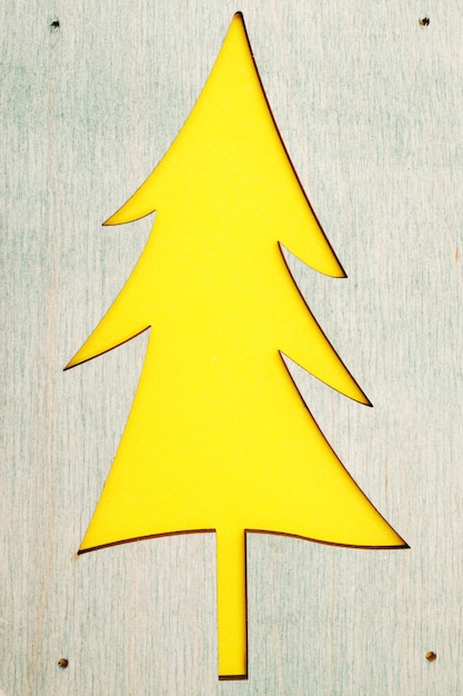 Wooden pattern of a Christmas tree on a yellow background.