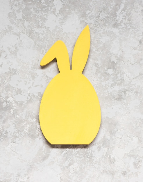 Coniglietto pasquale in legno per il designer. campioni gialli su sfondo grigio vista dall'alto
