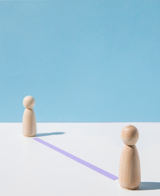 wooden pawns with coronavirus distance recommendation