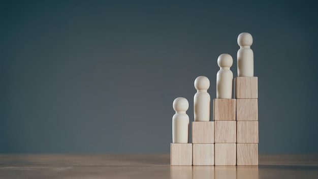 Wooden peg dolls on Stack of wooden blocks. Employees positions. Human resource management planning.