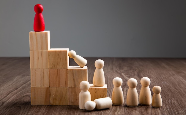 Wooden people figures on top of wooden blocks career growth\
development and leadership