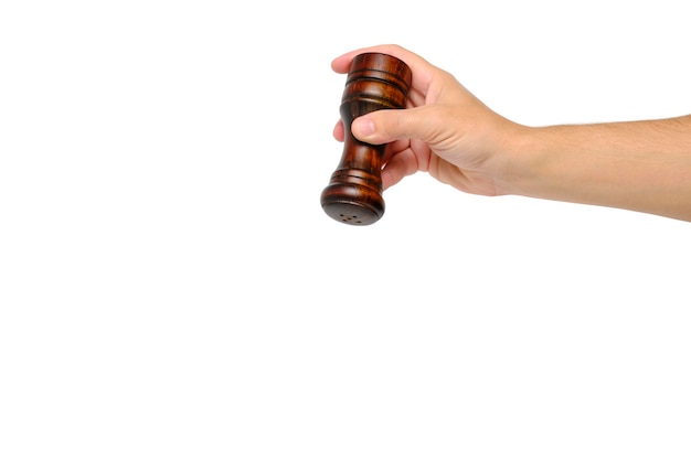 Wooden pepper pot in hand on a white background