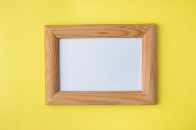 Wooden photo frame on yellow 