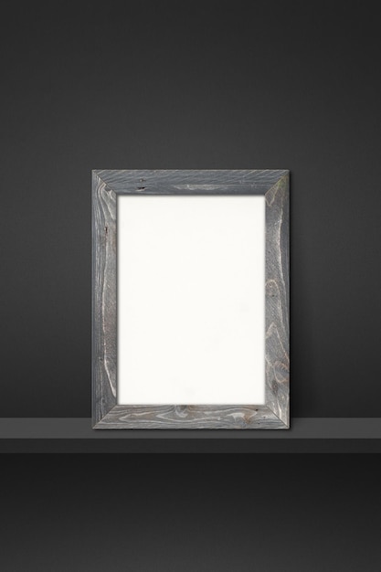 Wooden picture frame leaning on a black shelf 3d illustration Blank mockup template Vertical background