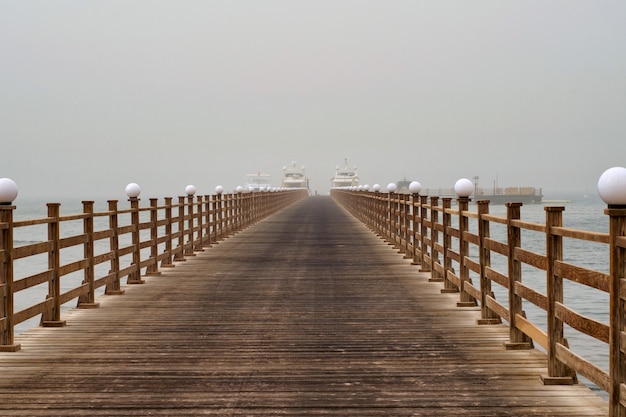 The wooden pier directs to the ships.