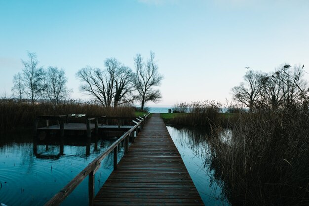 Wooden pier on lake against sky