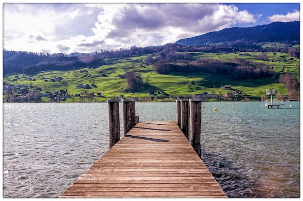 Wooden pier over lake against sky