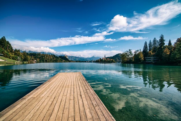 Wooden pier Lake Bled, Slovenia with blue sky and clouds in the autumn