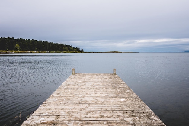 Wooden pier at ocean in cloudy day in Gaspe