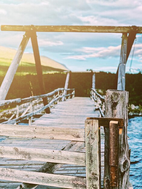 Wooden pier on sea against sky