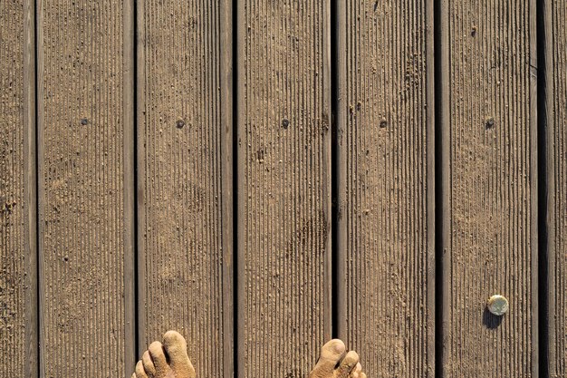 Photo wooden pier and toes in the sand on a sunny summer day