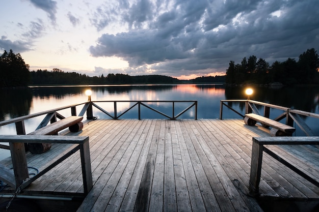 Foto molo di legno con lanterne che lasciano il lago