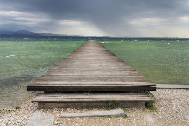 Wooden pier with waves on Lago di Garda Sirmione Italy