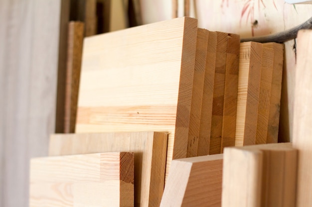 Wooden pillars and thick boards in the furniture workshop are ready to work joiner