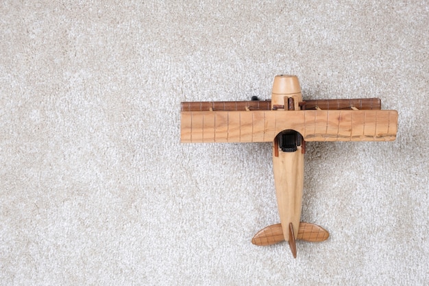 Wooden plane on a white carpet.