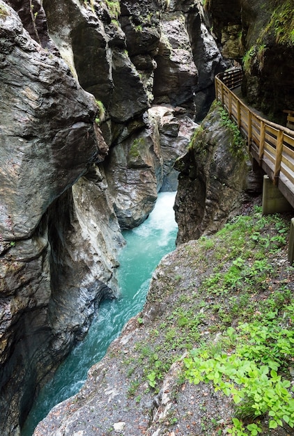 Passerella con assi di legno sopra la gola e il torrente liechtensteinklamm d'estate in austria.