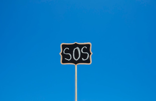 Wooden plaque with the word sos 