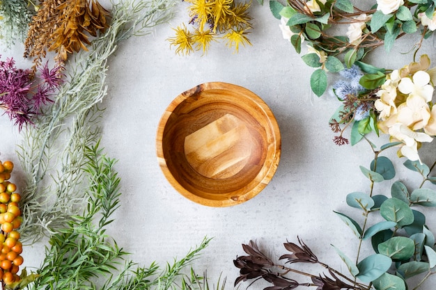 Wooden plate and botanical ornaments set on a marble table