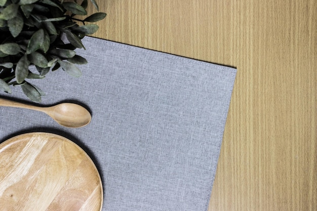 Wooden plate and spoon with plant on table