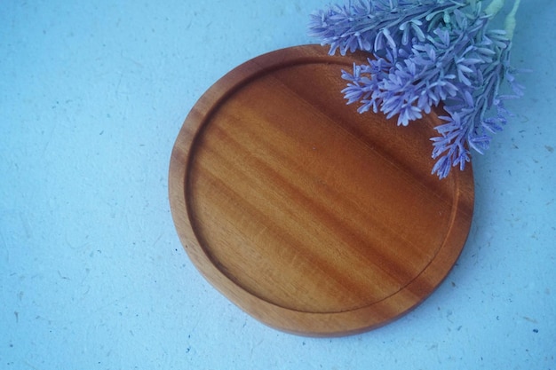 wooden plate with blue cornflowers on the blue background with copy space