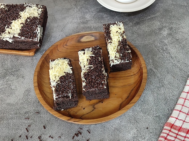 A wooden plate with chocolate cake on it