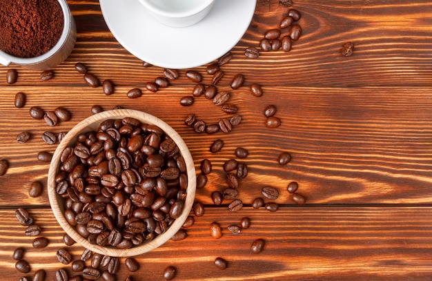 Wooden plate with coffee grains, ground coffee in a horn on a wooden table.Copy space.Top view.