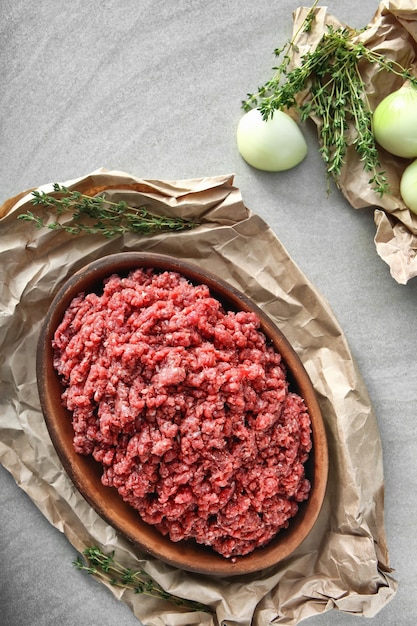 Wooden plate with fresh forcemeat on table