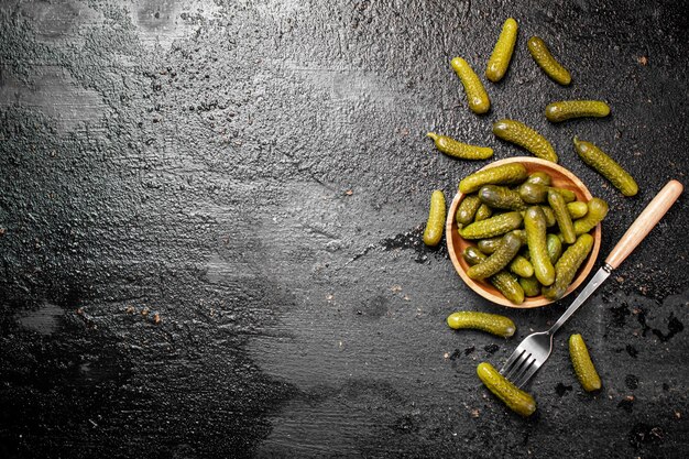 Wooden plate with pickles On a black background