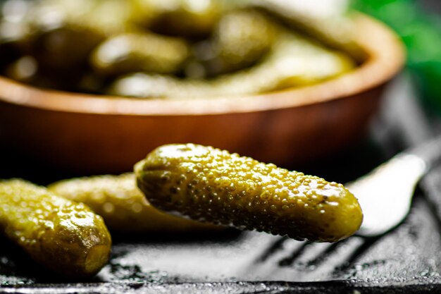 Premium Photo | Wooden plate with pickles on a black background