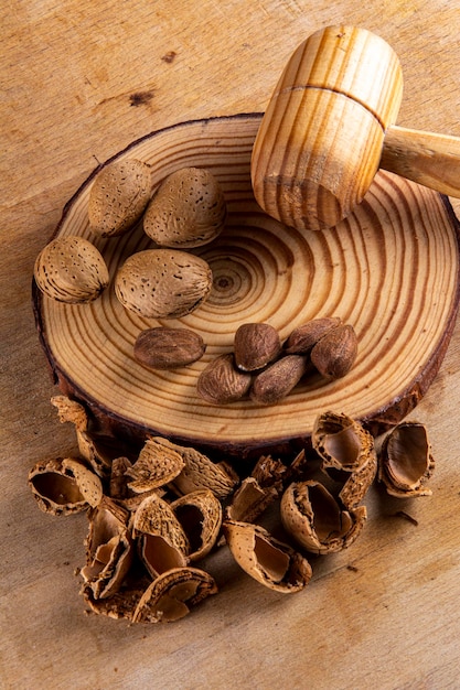 A wooden plate with a pile of walnuts and a wooden spoon with a wooden spoon on it.