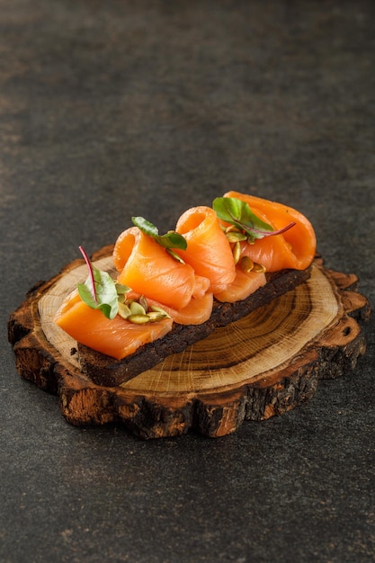 Wooden plate with sandwich with salmon