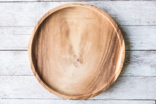 Wooden plate on wooden table background