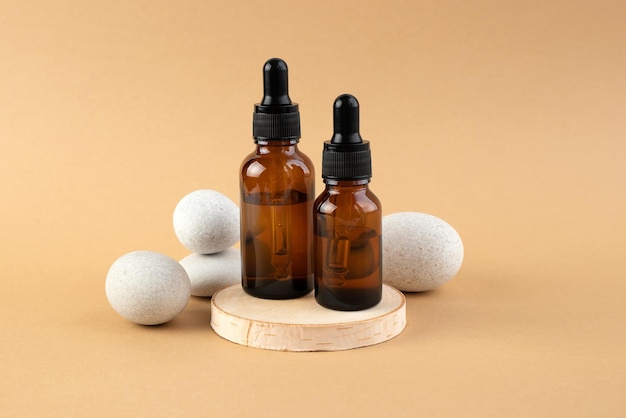 A wooden podium stones and a bottle with a pipette filled with oil or essence Body care concept natural spa cosmetics