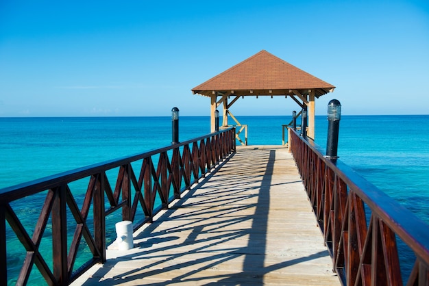 Wooden pontoon with canopy and with fence stretching into the sea