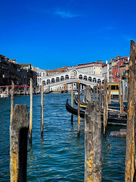 Foto pilota di legno nel canale in mezzo agli edifici contro il cielo blu