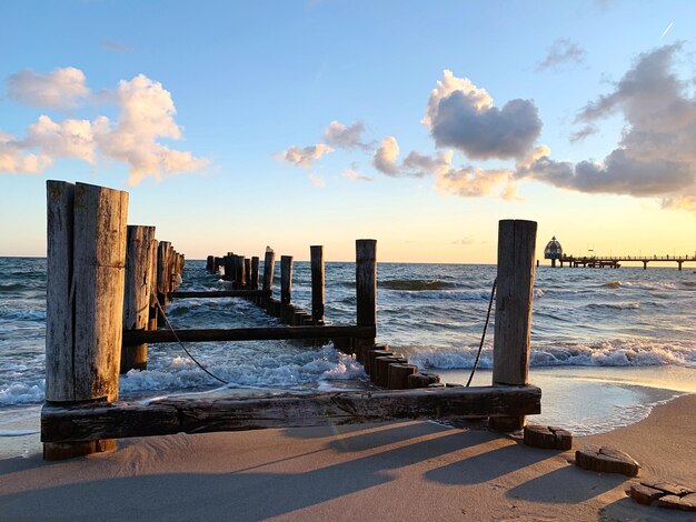 Photo wooden posts on beach against sky