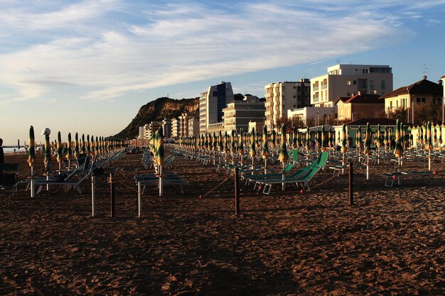 Foto postelli di legno sulla spiaggia da edifici contro il cielo