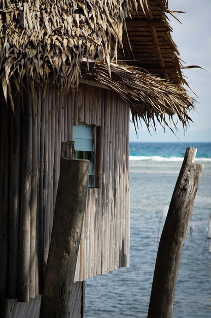 Photo wooden posts on house by sea against sky