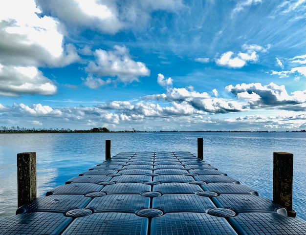 写真 空の向こうの海に木の柱