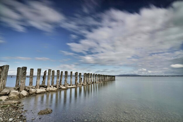 写真 空の向こうの海に木の柱