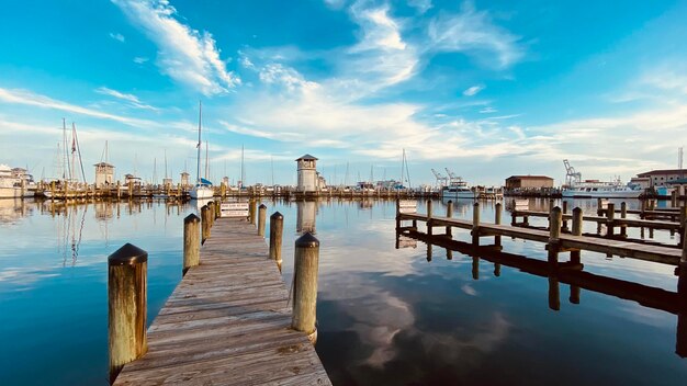 Wooden posts in sea against sky